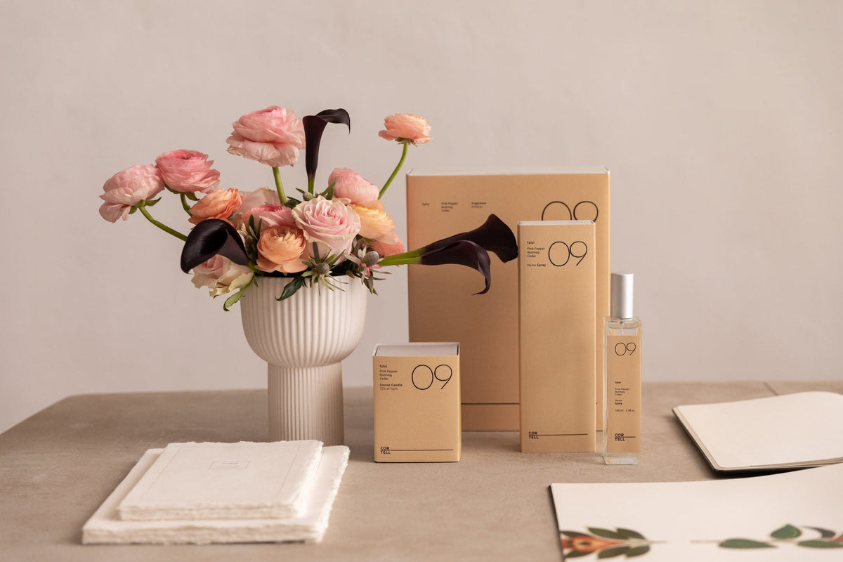 Estuches de la fragancia Talvi 09 de Cortell junto a un ramo de rosas