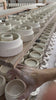 Filas de piezas de porcelana secando en las baldas del taller de Cortell